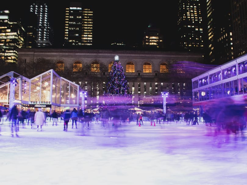 crowd on ice rink during night in Bryant Park NYC
