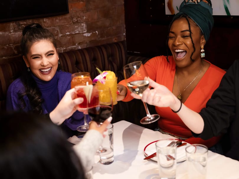 Guests raising their drinks in a toast at a Broadway dinner in New York